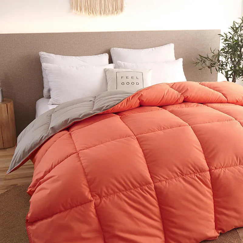 Goose down winter duvet with twill fabric cover, shown in a grey colour on a bed.