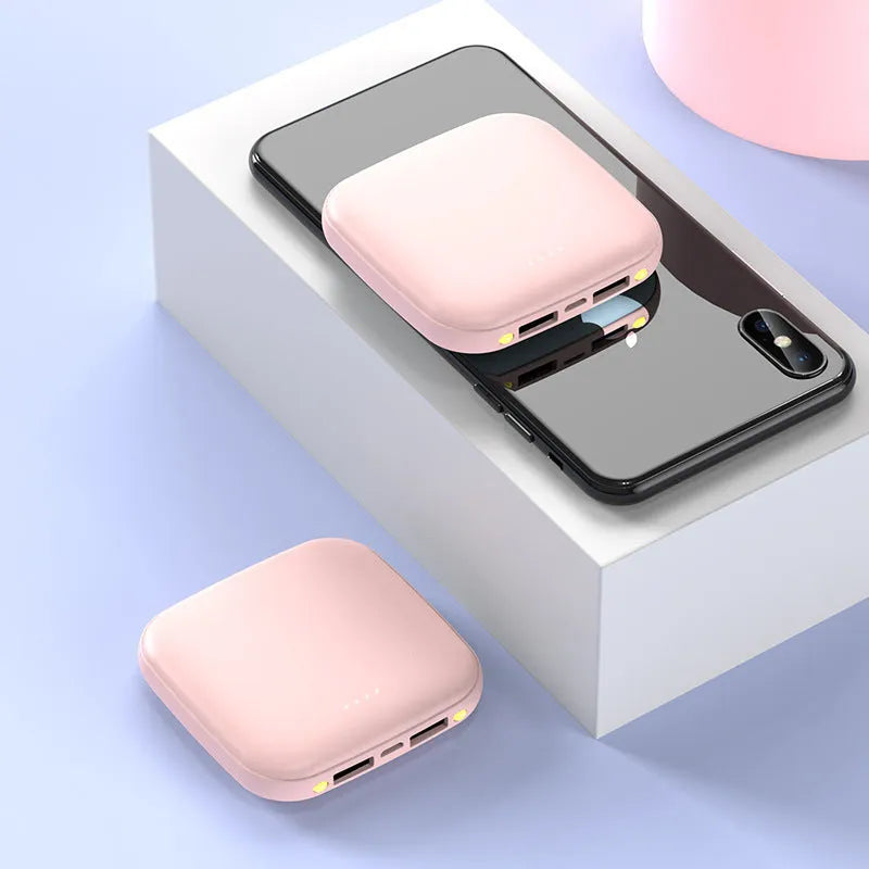 Mini black plastic power bank with an LED flashlight, showing scale against a hand.