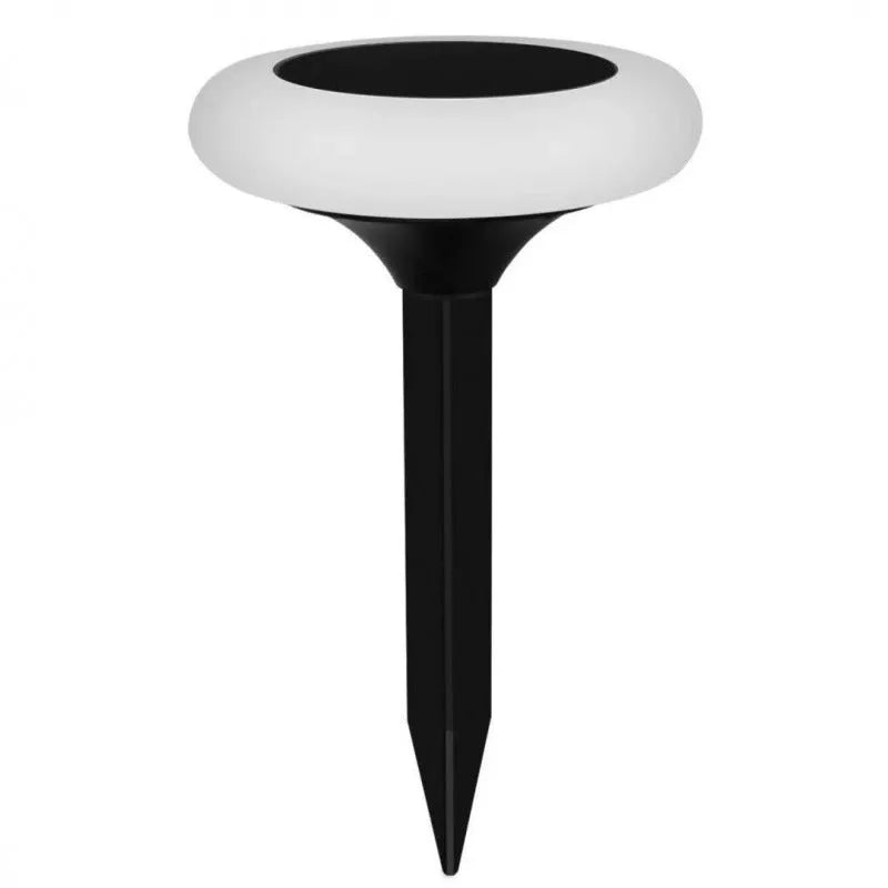 Round solar lawn light with colour gradient finish on garden soil near flowers