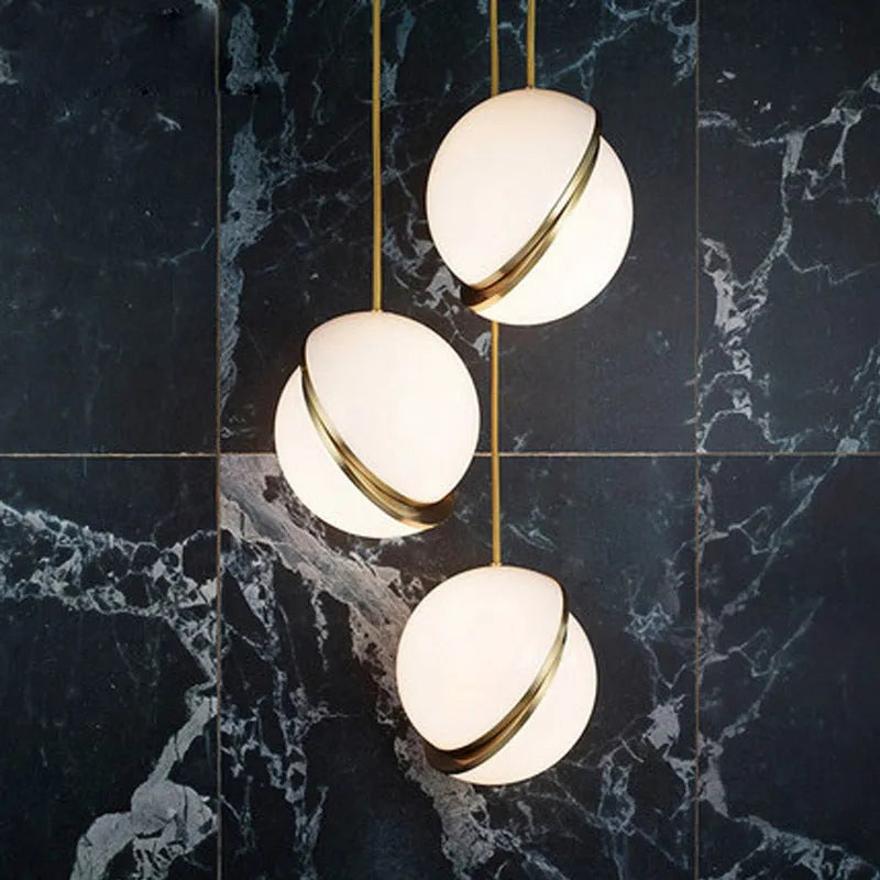 Nordic pendant light with white spherical shade hanging on adjustable cord