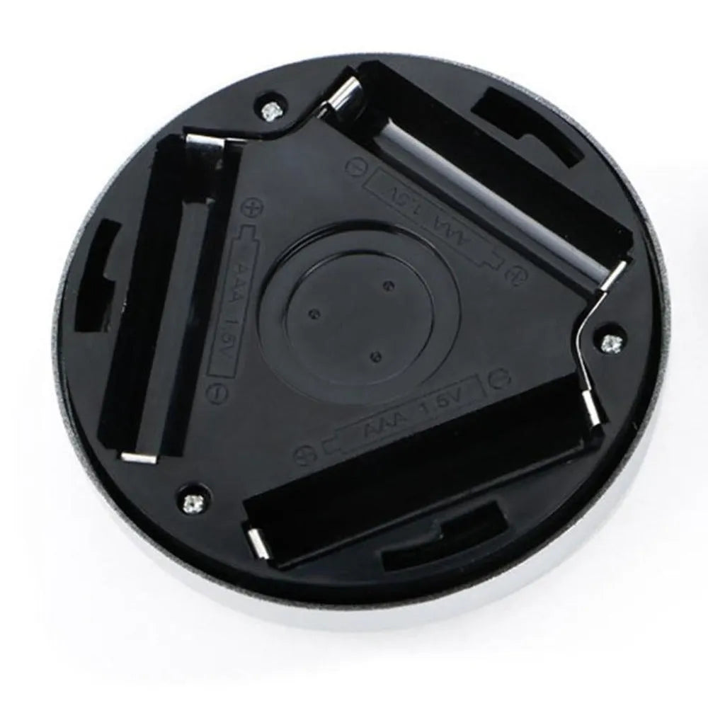 Silver coloured circular wireless motion sensor night light on a wall.