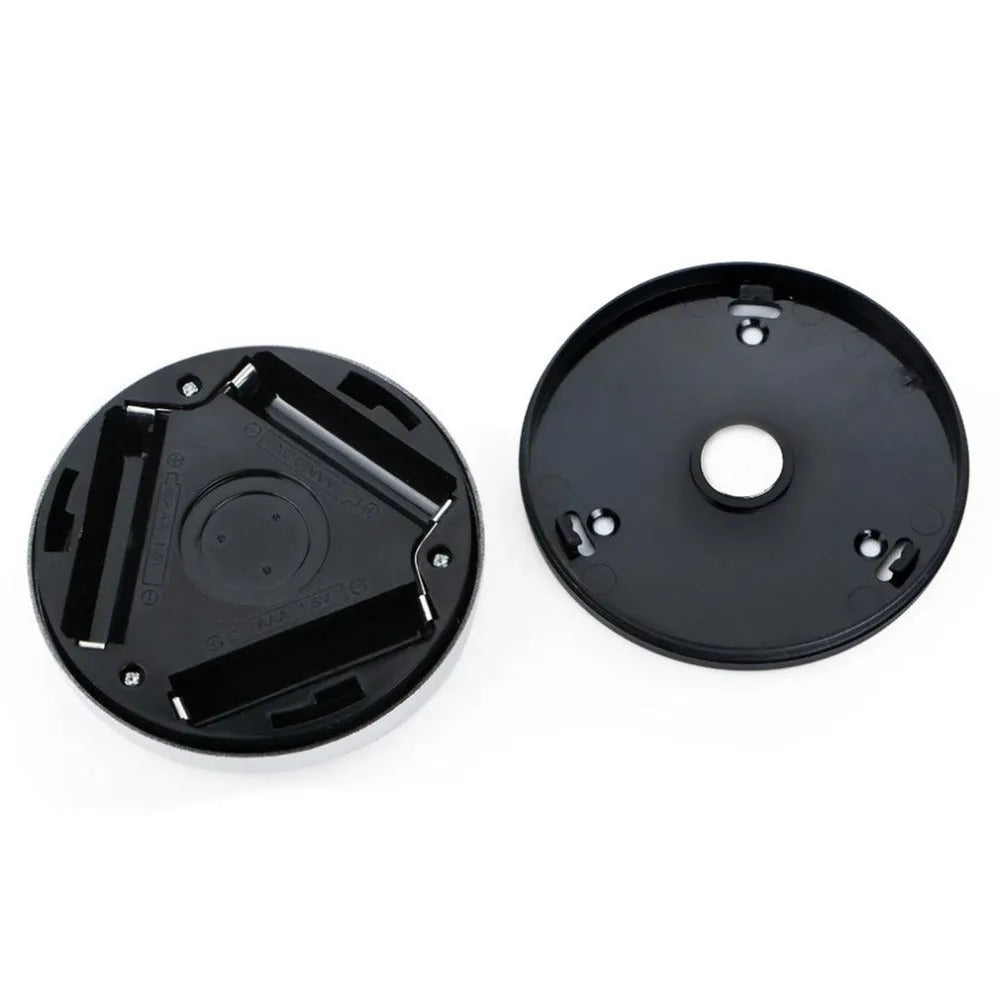 Silver coloured circular wireless motion sensor night light on a wall.