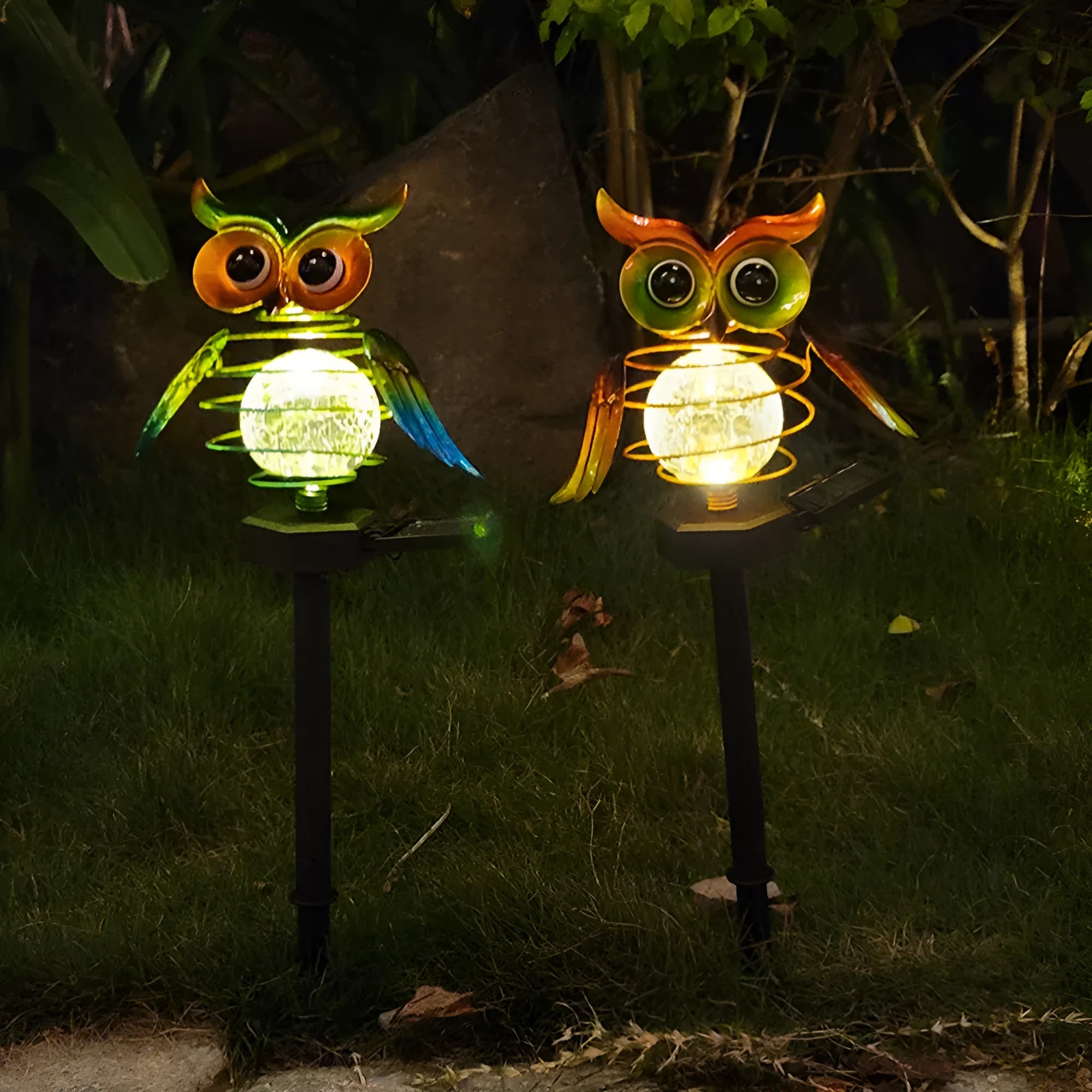 Solar-powered owl lawn lamp with iron sculpture and glass lampshade in a garden setting