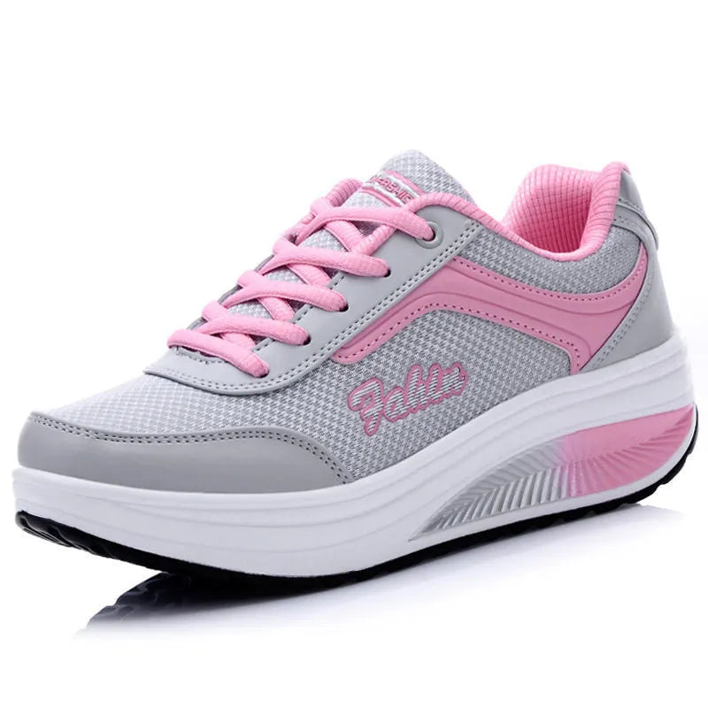 Women's grey powder heelless sports shoe with a mid-heel, shown on a neutral background.