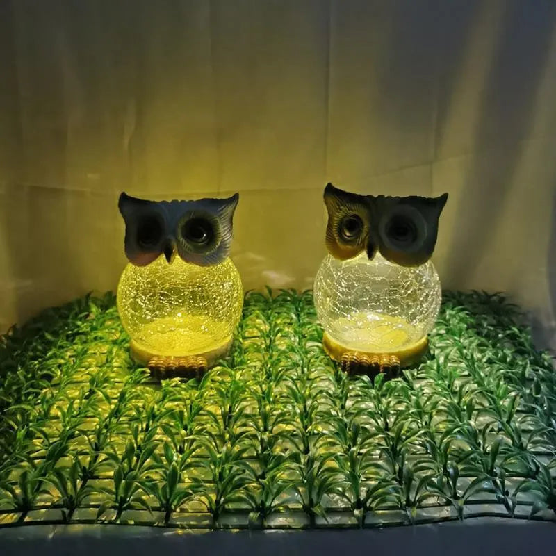 White and yellow LED solar-powered owl statue light for outdoor garden decoration.
