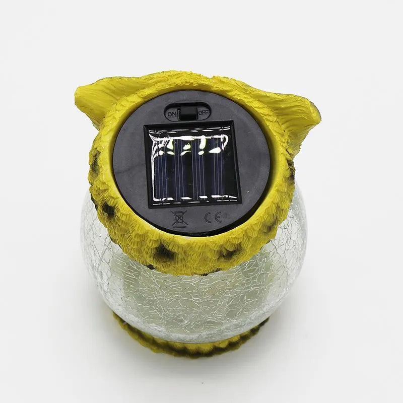 White and yellow LED solar-powered owl statue light for outdoor garden decoration.