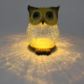 White and yellow LED solar-powered owl statue light for outdoor garden decoration.