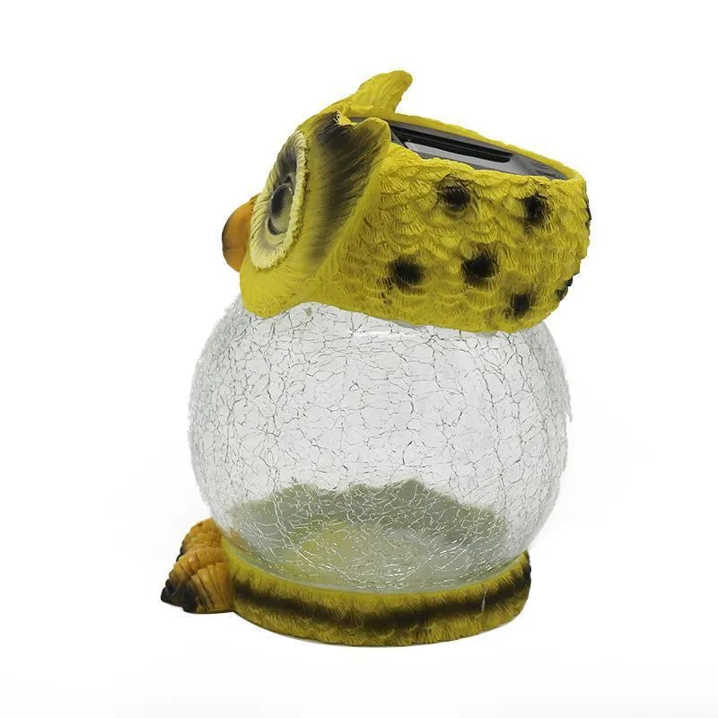 White and yellow LED solar-powered owl statue light for outdoor garden decoration.