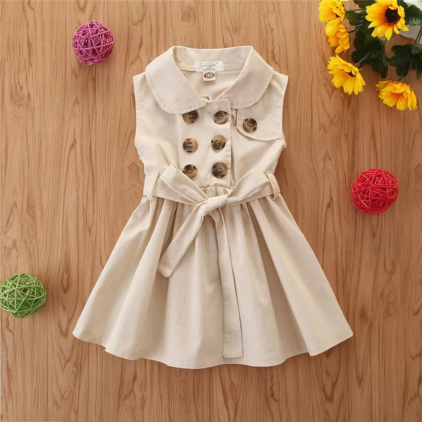 Baby girl in a sleeveless cotton A-line princess dress with a sash and button detail.