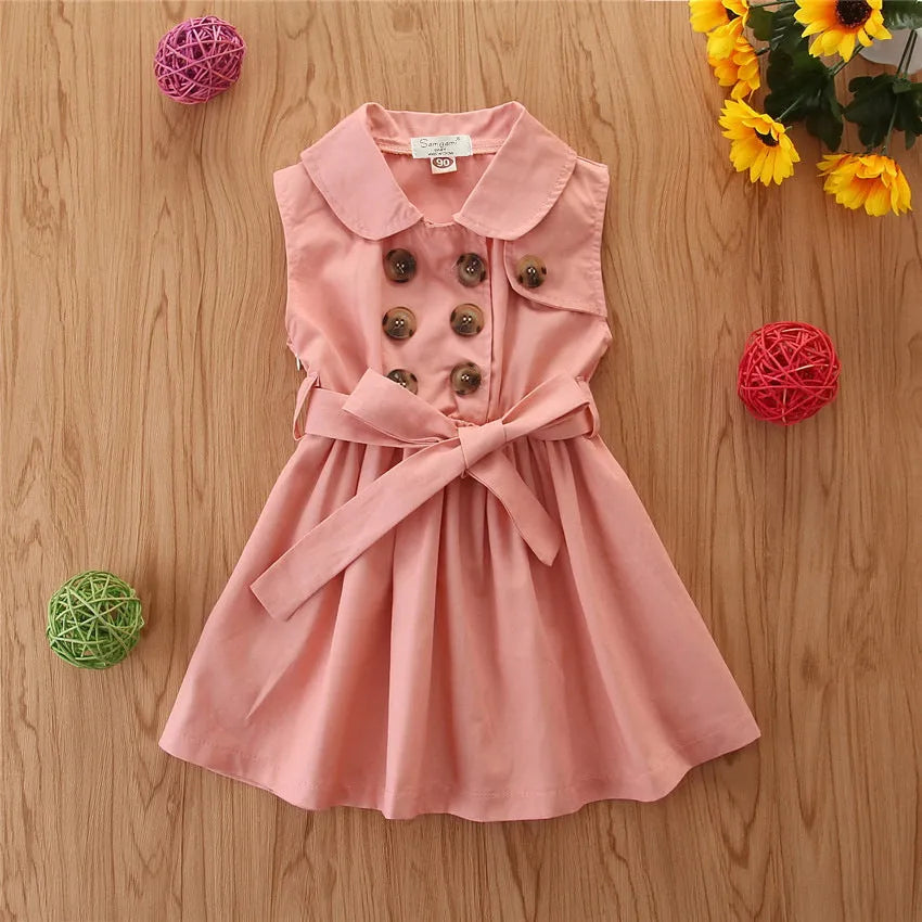Baby girl in a sleeveless cotton A-line princess dress with a sash and button detail.