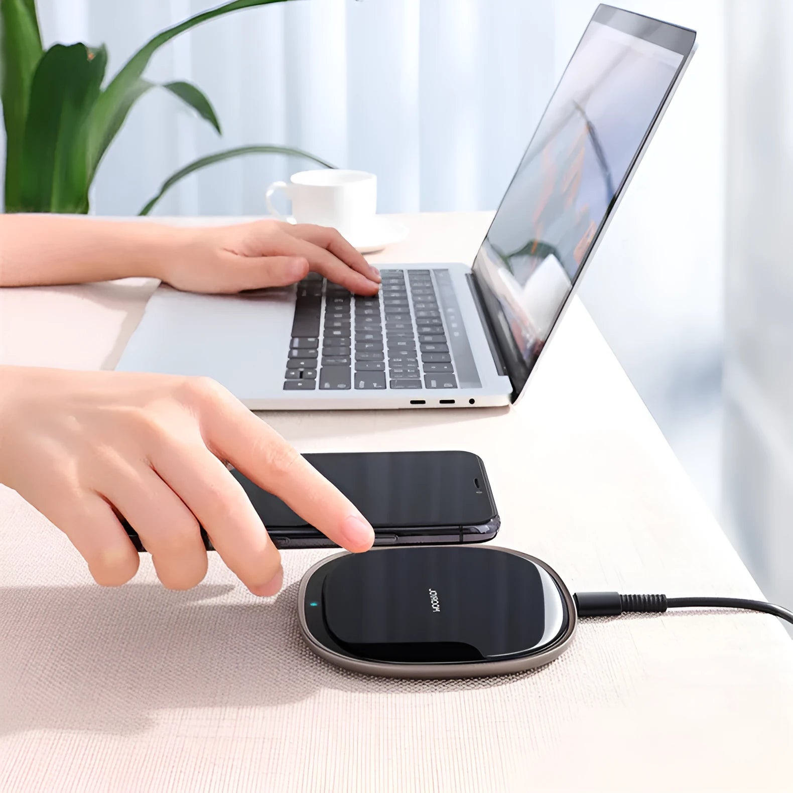 Black 15W wireless charging pad with zinc alloy rim and glass top on a wooden desk