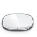 Black 15W wireless charging pad with zinc alloy rim and glass top on a wooden desk