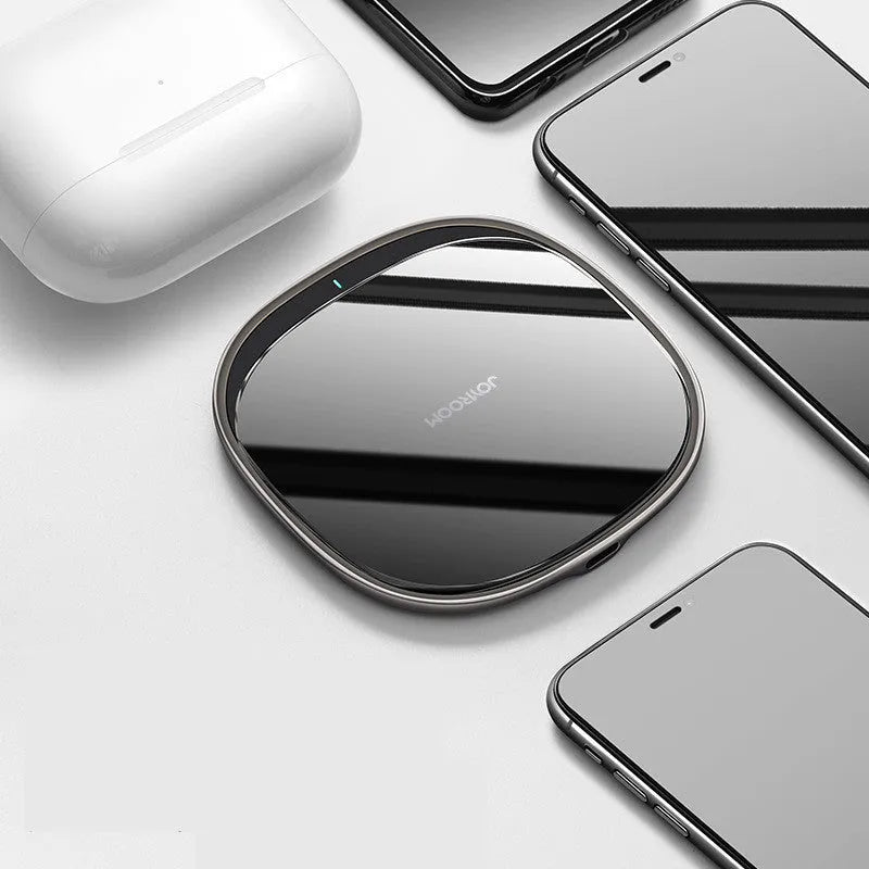 Black 15W wireless charging pad with zinc alloy rim and glass top on a wooden desk