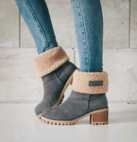Women's black suede mid-tube snow boots with a thick heel and round toe on a waterproof platform.