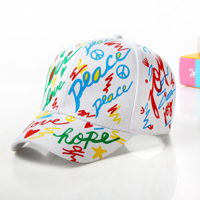 Children's cotton baseball cap with graffiti design, shown in black, pink, red and white colour options.