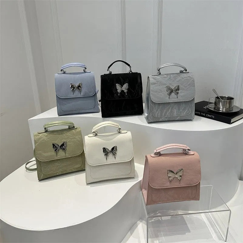 Preppy style white PU women's backpack with a black detachable bow decoration and visible stitching.