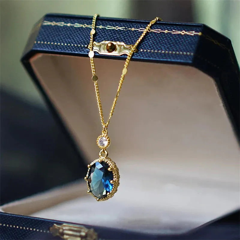 Gold geometric pendant necklace with a French retro design on a model.