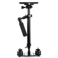 Black aluminium handheld camera stabilizer with adjustable height on a table.