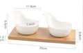 White porcelain snack dish with compartments on a wooden board
