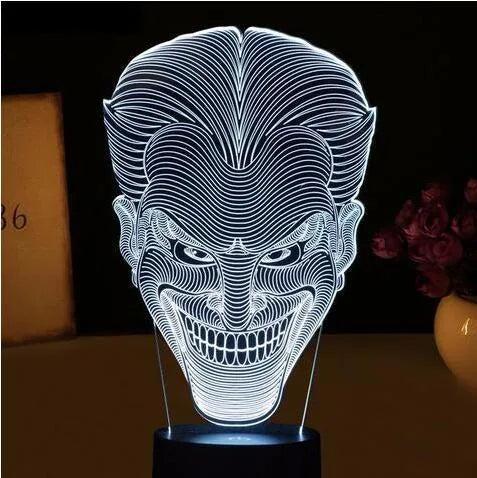 A modern 3D LED table lamp with a colourful gradient display, sitting on a square base with a USB cable.