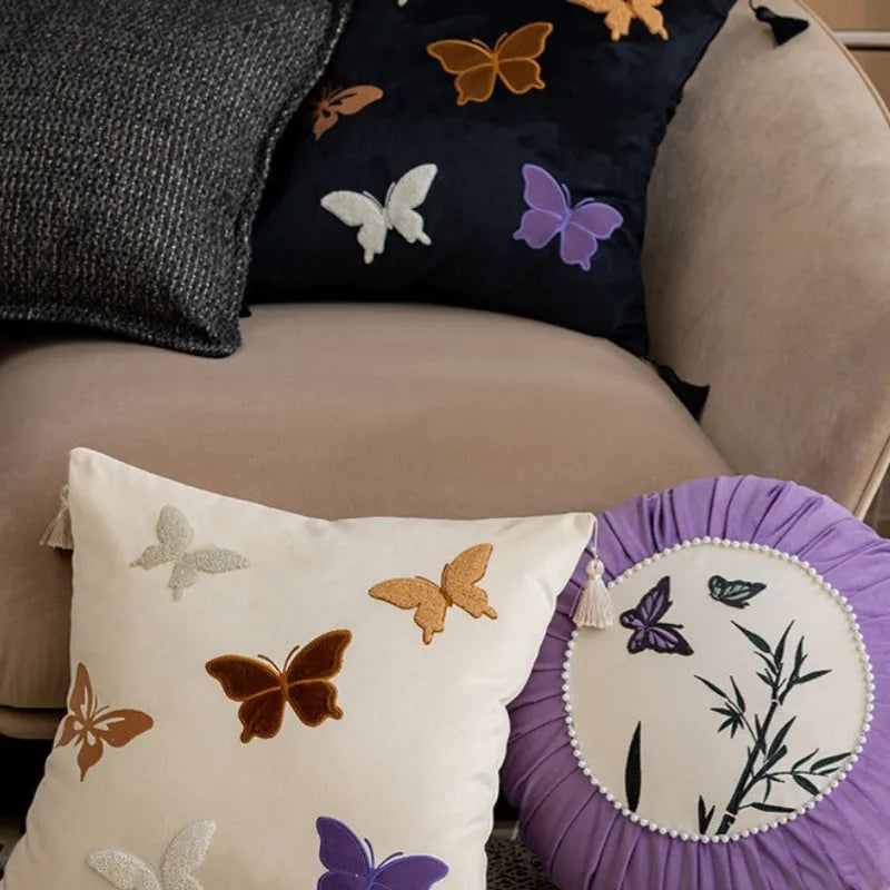 Square beige couch pillow with embroidered Chinese-style butterfly design.