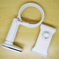 Black bedside oversize flat panel handset holder with a long arm on a wooden table.