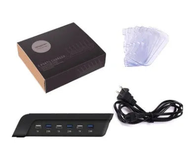 Six-port USB mobile phone charging stand in silver with multiple phones and tablets inserted, on a wooden desk