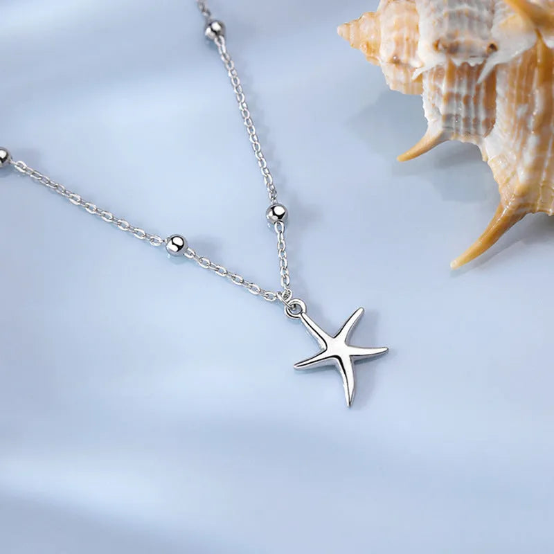 Adjustable sterling silver anklet with a detailed starfish charm and round beads on a silver chain.