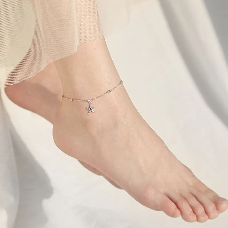 Adjustable sterling silver anklet with a detailed starfish charm and round beads on a silver chain.