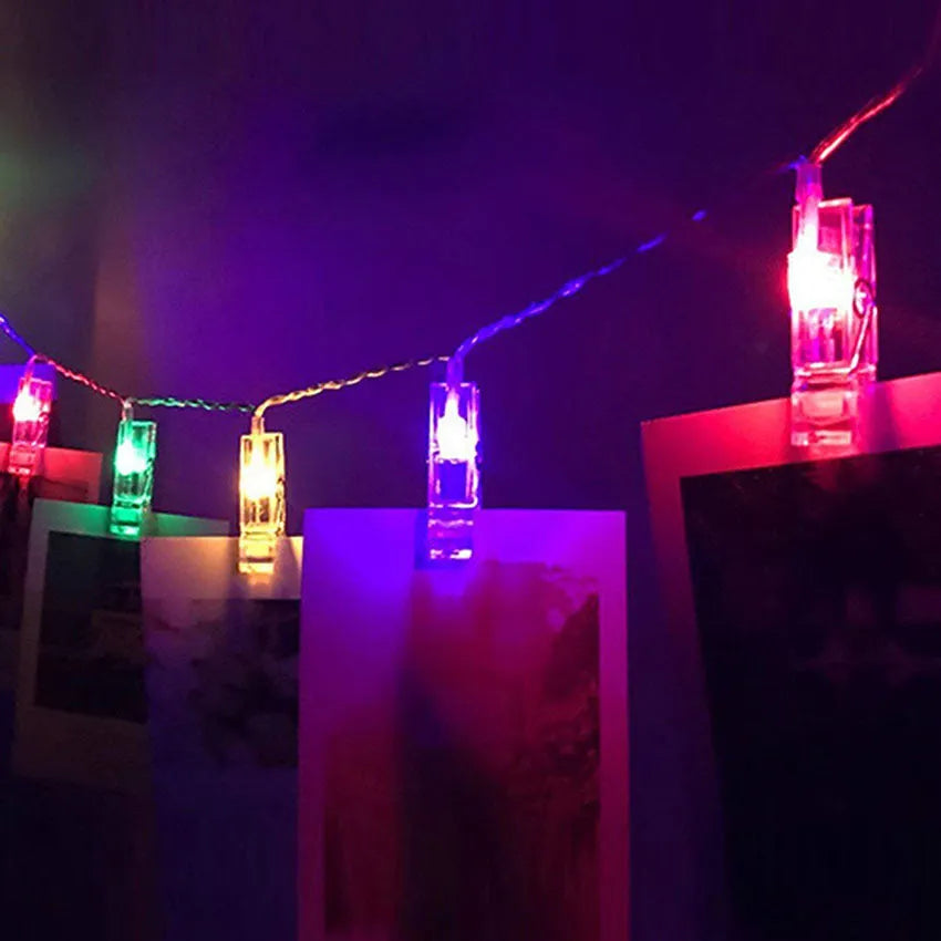 LED photo holder string lights with warm white bulbs and photo clips on a window display