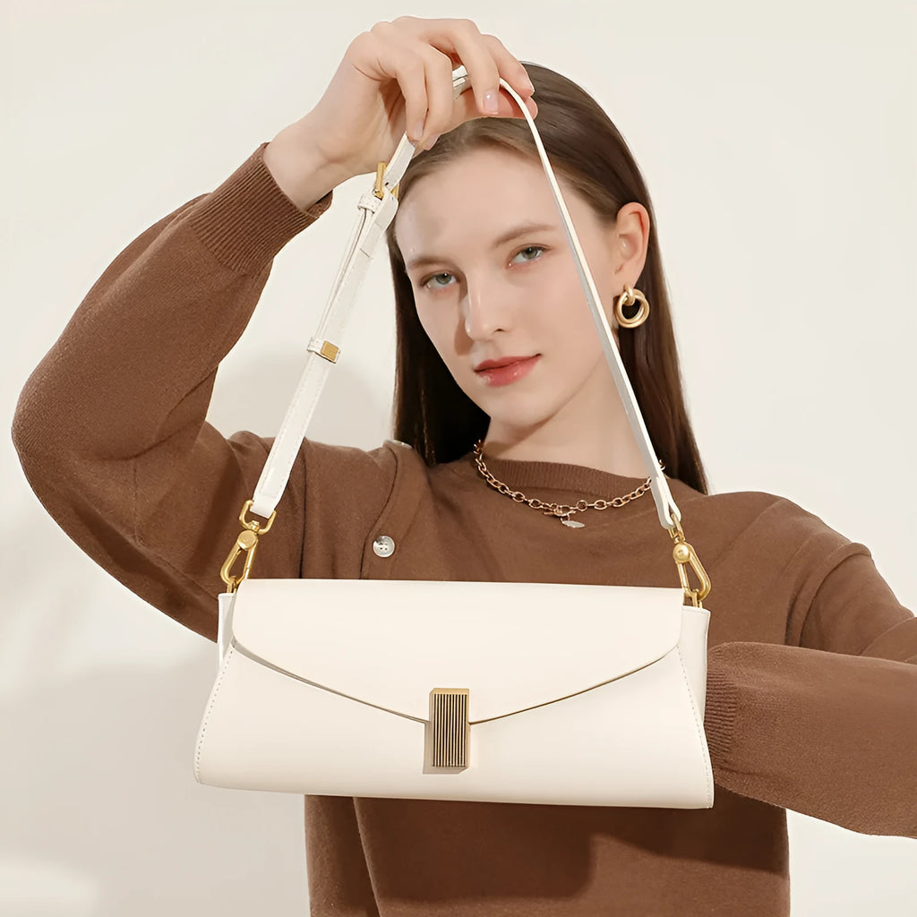 Women's leather cross-body shoulder bag in clamshell design with internal organisers.