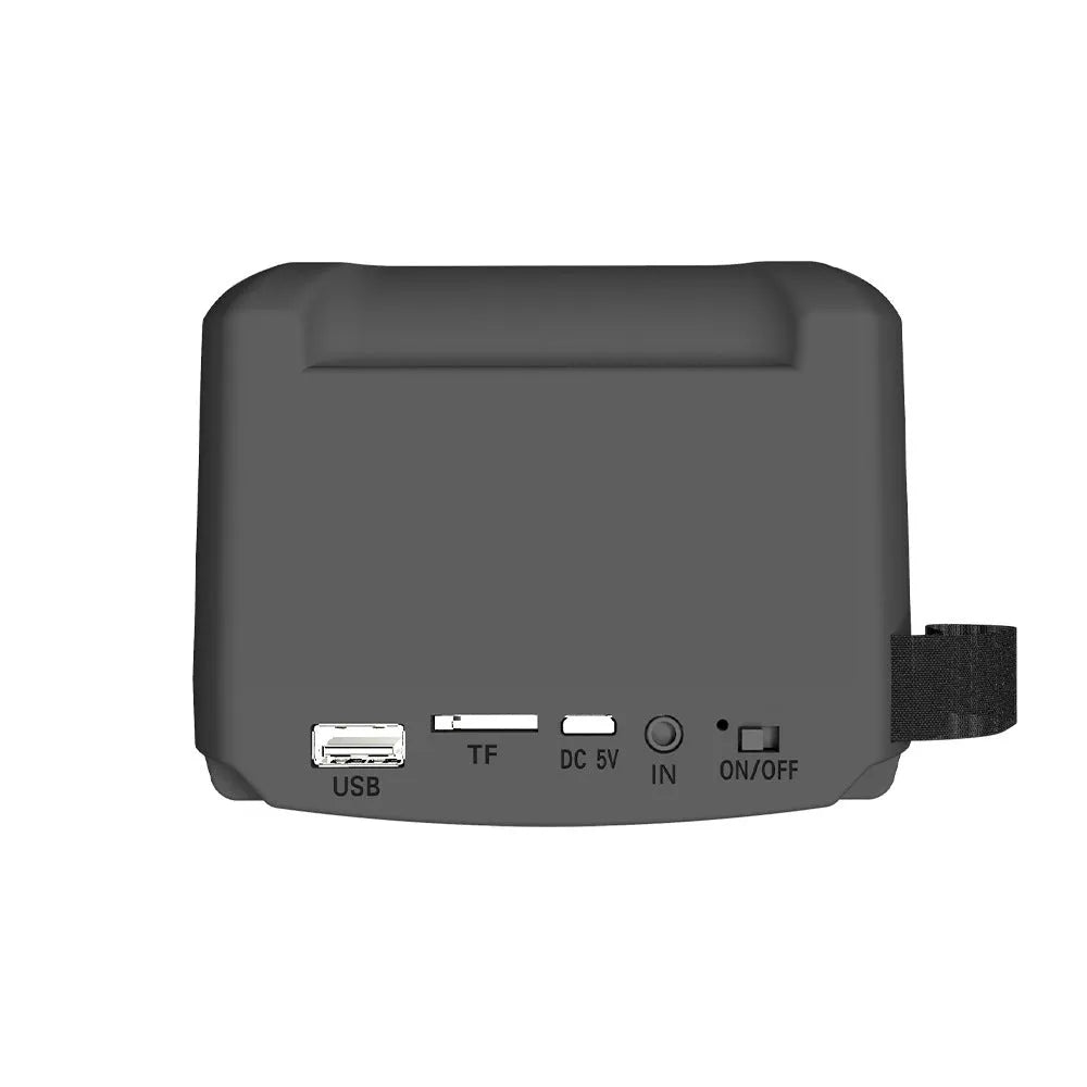 Compact portable Bluetooth speaker with USB charging cable on a table.
