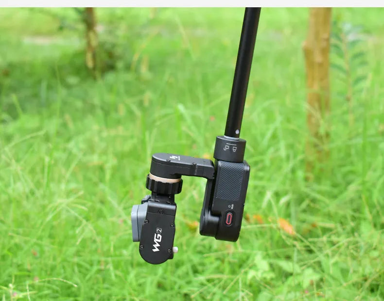 Black retractable aluminium selfie stick with Bluetooth remote, extended with a phone in the holder.