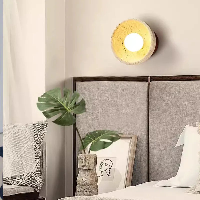 Yellow cave stone wall lamp with textured finish installed above bedside table