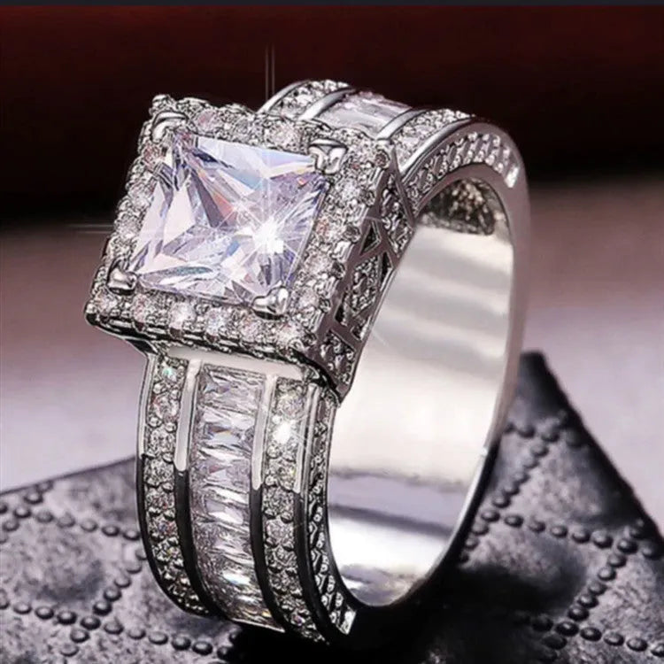 Geometric women's fashion ring with a round detail, shown in gold and white finishes on a hand.