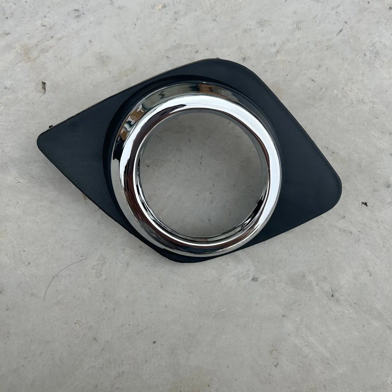 Black anti-fog light cover trim piece for Toyota RAV4 front bumper.