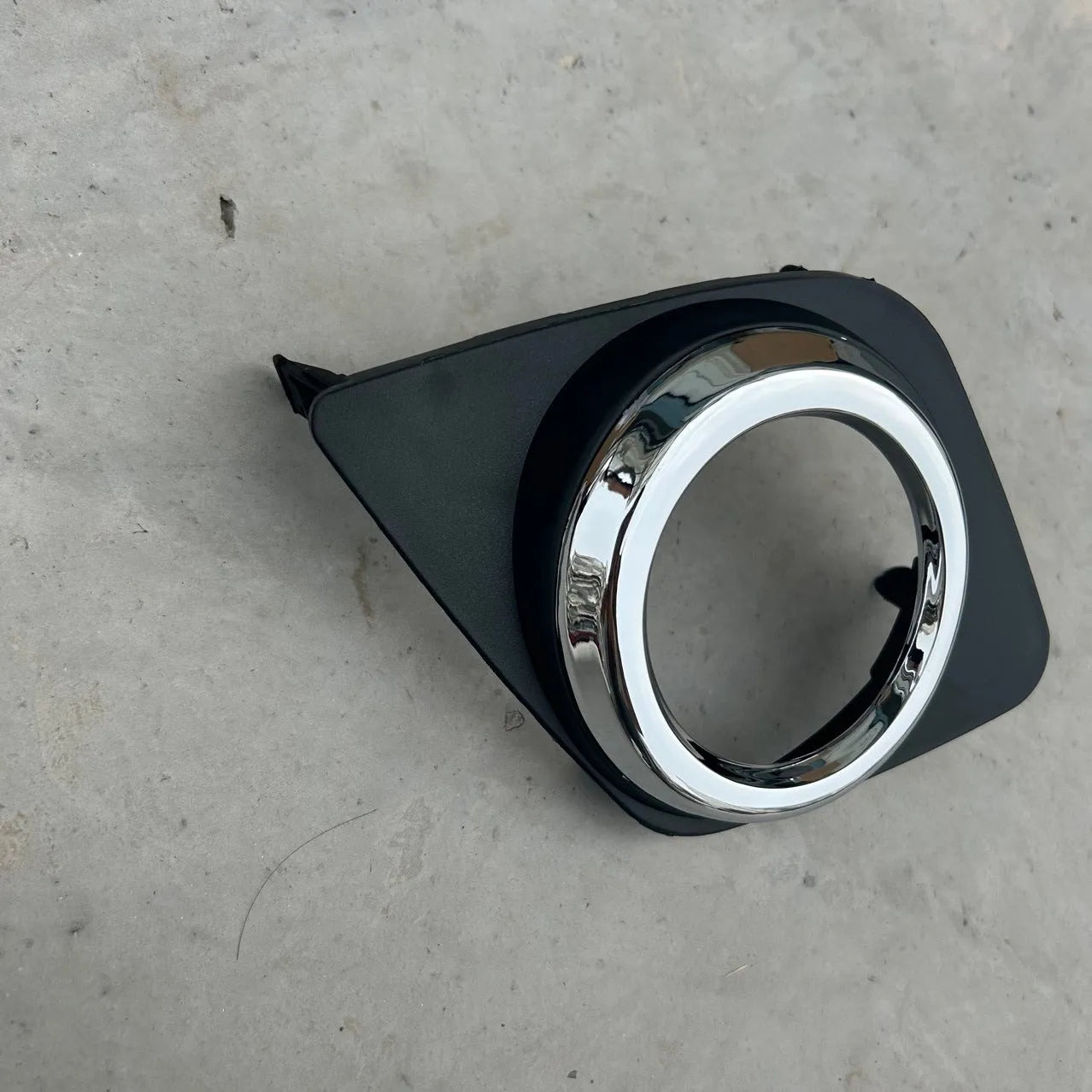 Black anti-fog light cover trim piece for Toyota RAV4 front bumper.