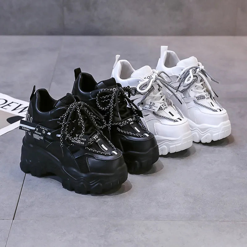 Women's white low-top platform sports shoes with a mesh upper and cross-strap detail.