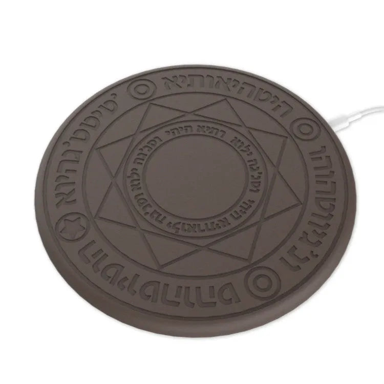 Square black wireless charging pad with glowing magic array pattern, charging a mobile phone.