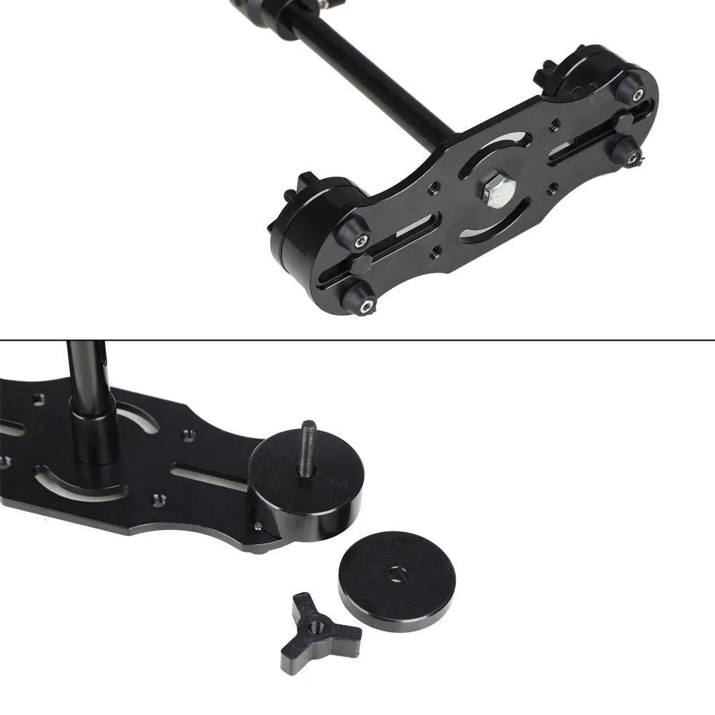 Black aluminium handheld camera stabilizer with adjustable height on a table.