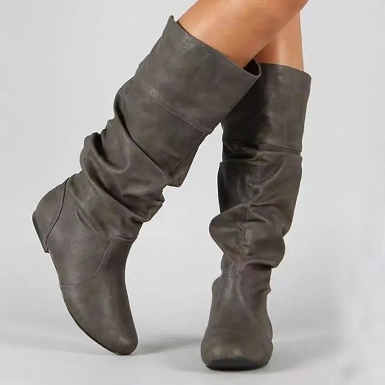 Women's flat black slip-on ankle boots with a round toe and high-top design on a neutral background.