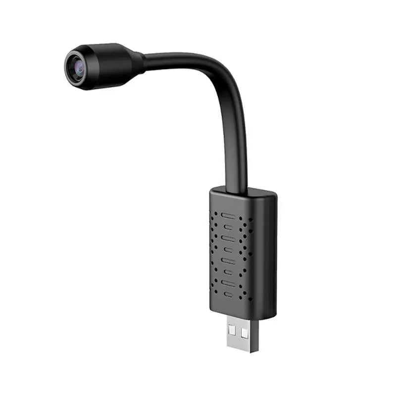 Black V380 wireless USB security camera on a wooden shelf next to a house plant.