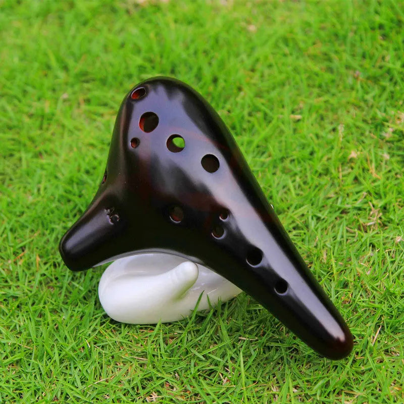 Smoked brown 12-hole dolomite ocarina, 14x8cm, midrange C, with raw lacquer surface.