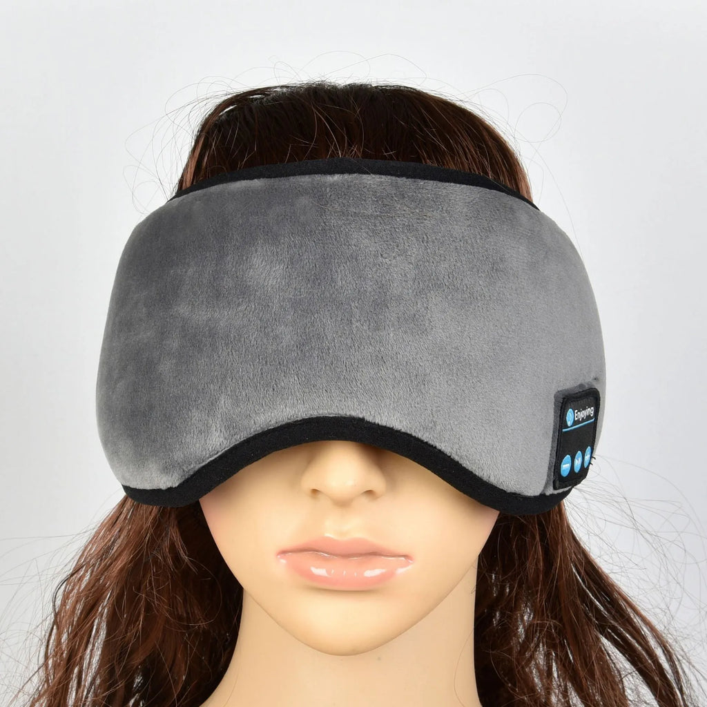 Black sleep eye mask with soft silk fabric, adjustable strap, and carry case on a light background