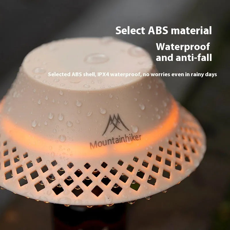 Beige recycled wine bottle camping lantern with USB-C port, showing warm light glow.