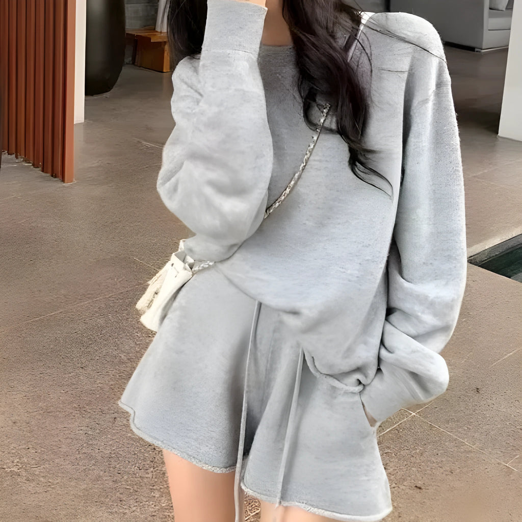 Woman wearing a loose grey knitted long sleeve sweater and matching wide-leg shorts set, front and back view.