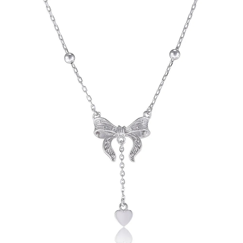 Silver necklace with heart-shaped pendant featuring bow detail on O-ring chain
