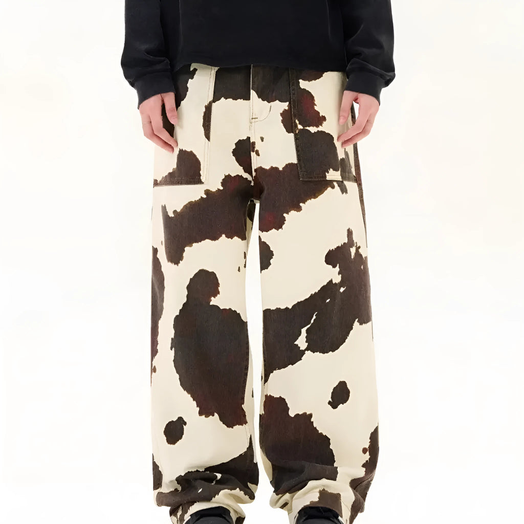 Men's straight-leg casual trousers featuring a black and white cow print pattern with a button fly.