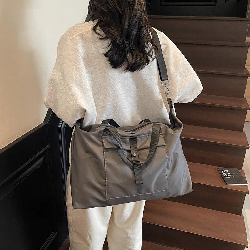Large one-shoulder travel bag in Oxford cloth showing black, grey, and green colour options.