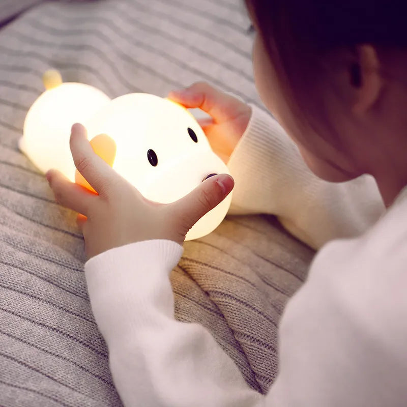 Dull Wang rechargeable silicone touch dimmable night light on a bedside table showing warm white glow